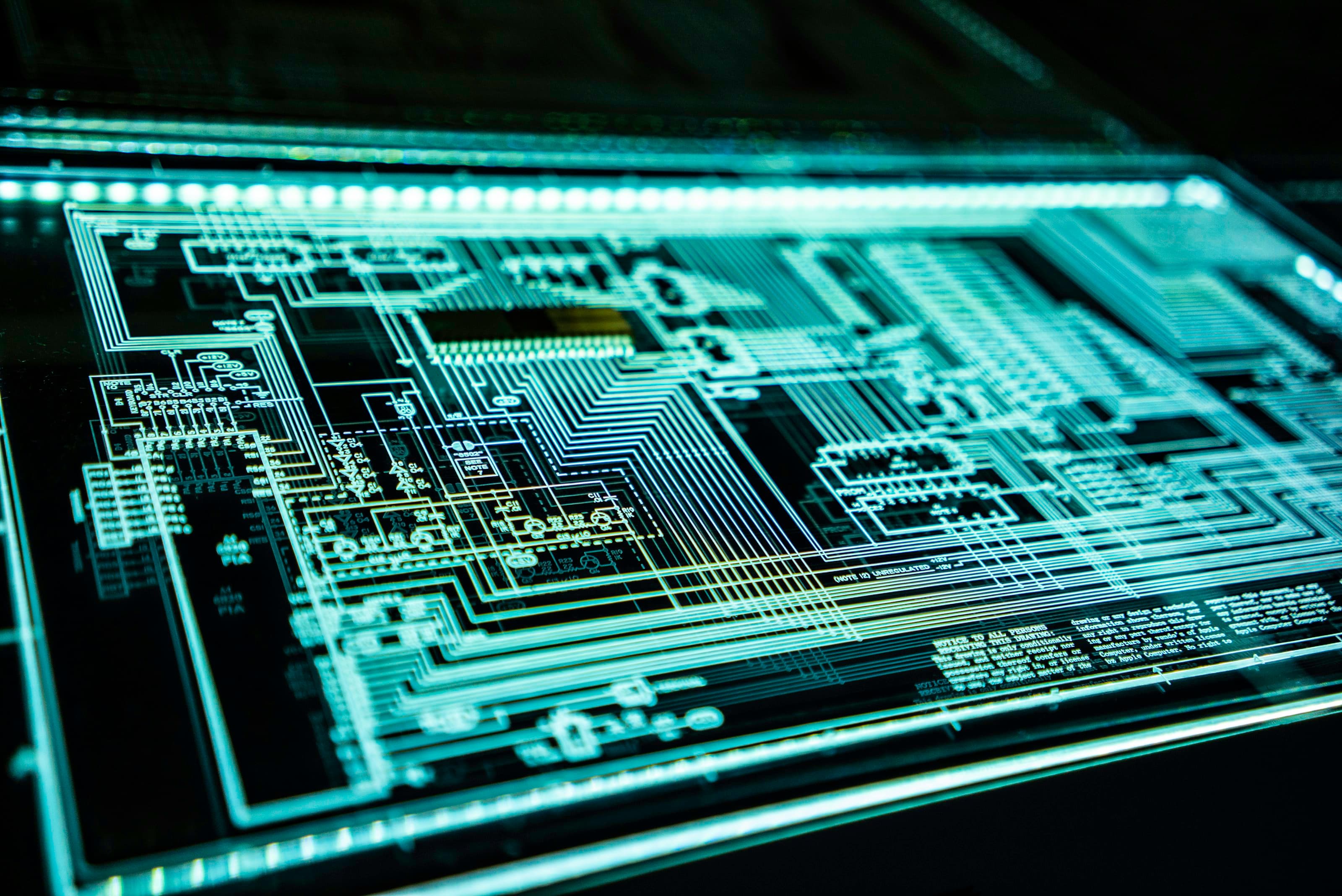 Illuminated circuit board schematic on a dark background